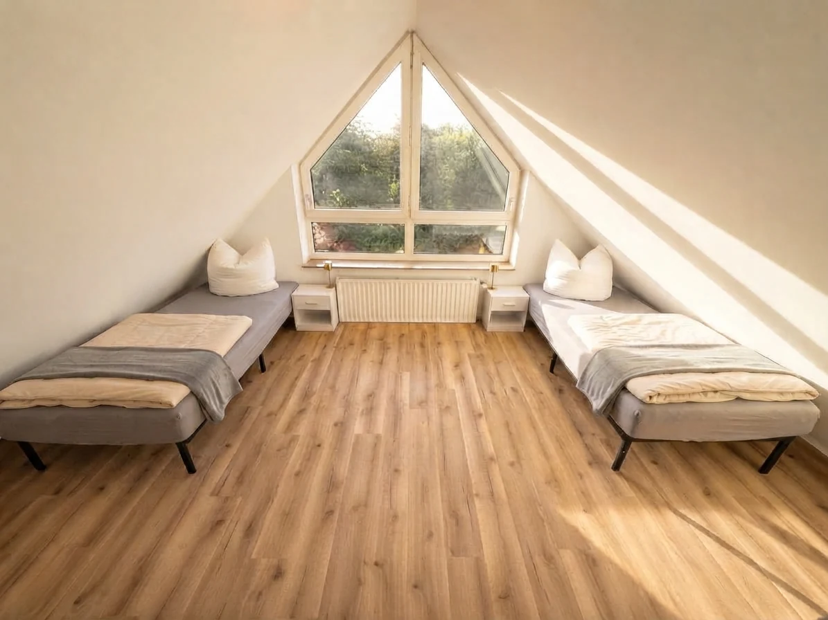 Schlafzimmer im Dachgeschoss mit zwei Einzelbetten und Blick ins Grüne