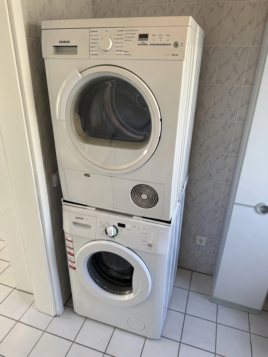 Waschmaschine und Trockner im Waschraum hinter dem großen Badezimmer